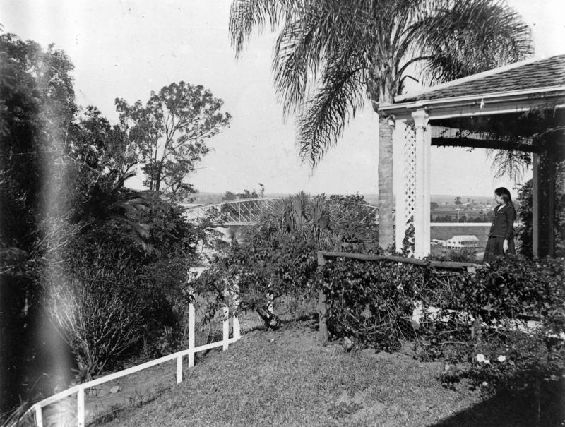 Young girl looking towards the Indooroopilly rail bridge and the Brisbane River, from the verandah of The Priory, ca. 1904
