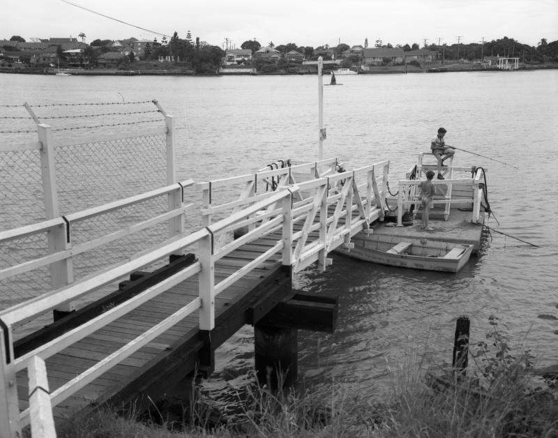 This is an image of ‘Norman Park Ferry Landing’, c. 1964, viewed from the south bank of the Brisbane River, Norman Park, Brisbane; looking north-west.
