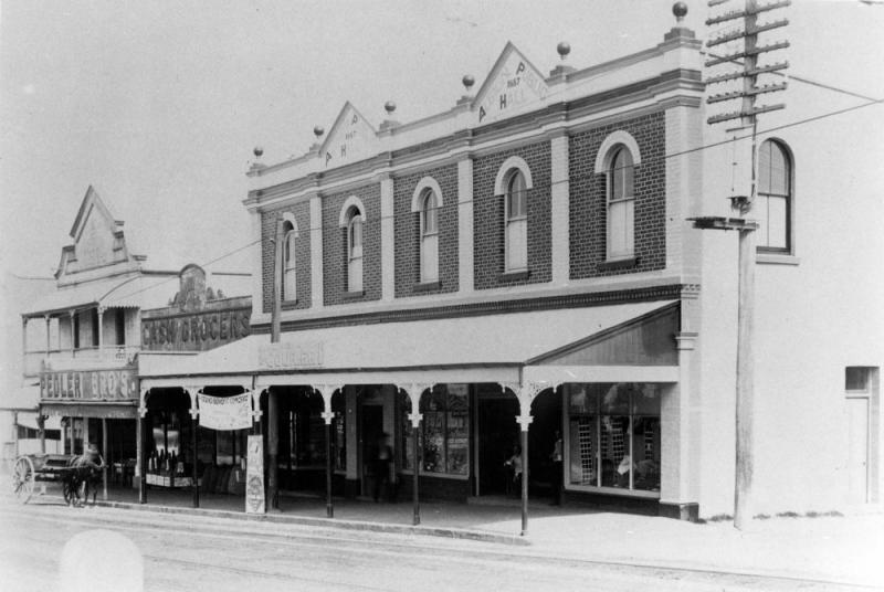 This is an image of ‘Shops in Albion, Brisbane, 1909’, looking west from the intersection of Sandgate Road and Birkbeck Street, Albion.