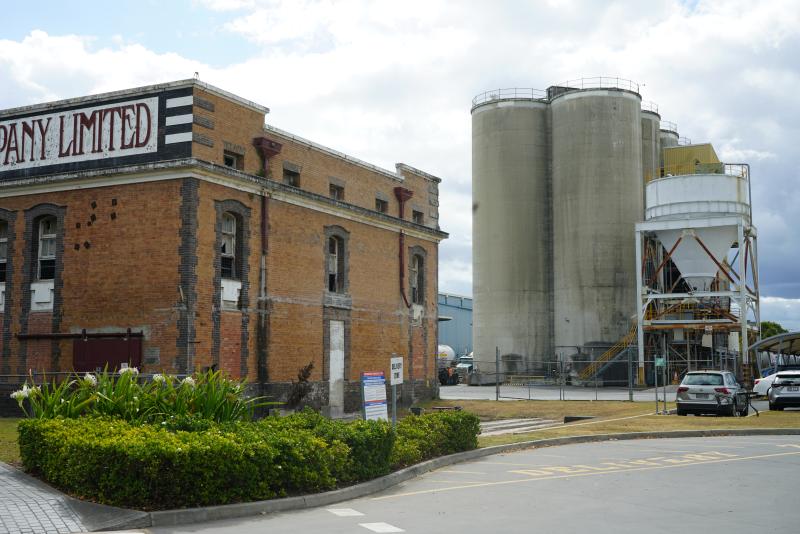 Front three quarter view of the former powerhouse with the modern cement factory in the background