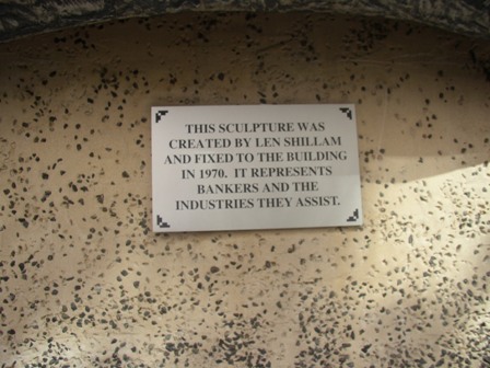 This is an image of the local heritage place known as 'The Banker' sculpture showing the plaque which reads 'This sculpture was created by Len Shillam and fixed to the building in 1970. It represents bankers and the industries they assist.'