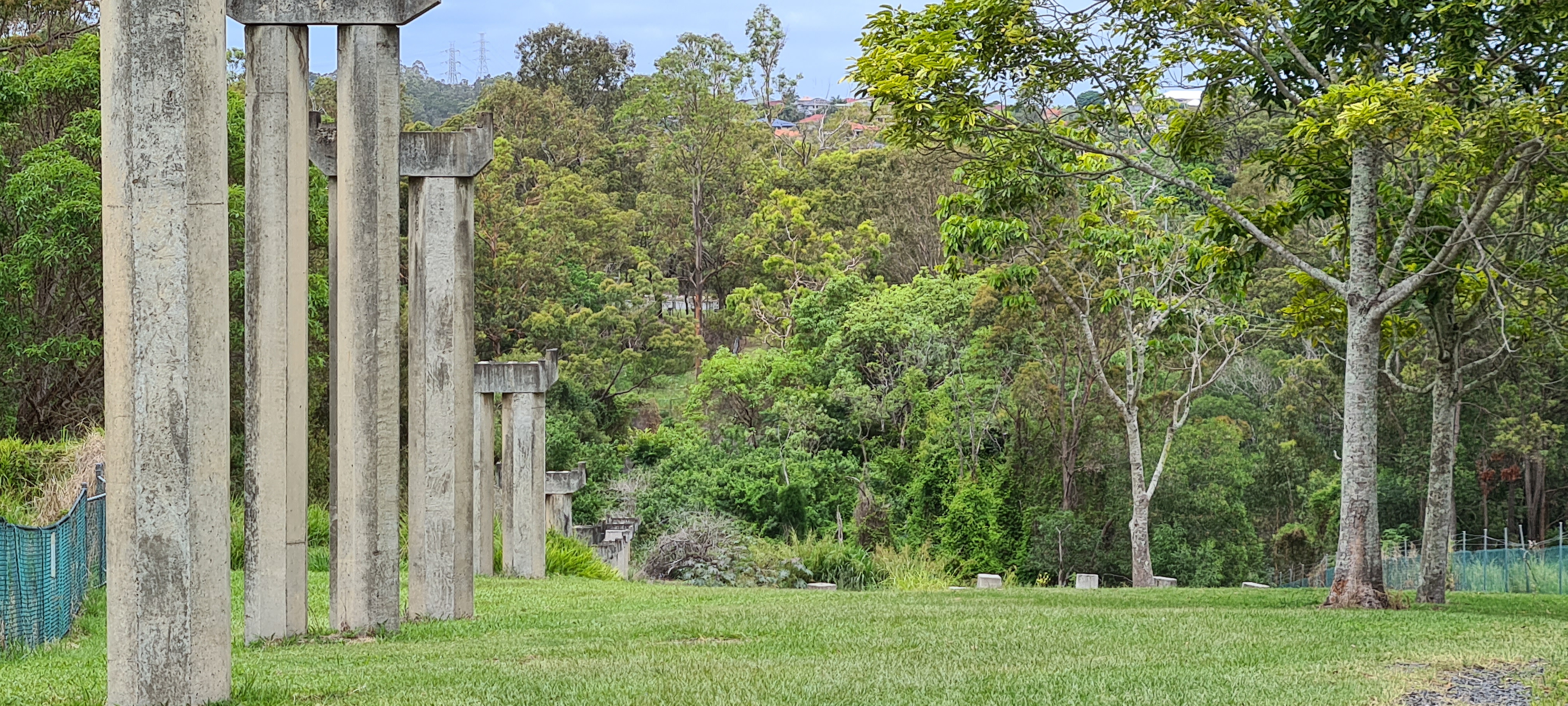 This is an image of concrete conveyor belt supports (remnants) - Queensland Cement and Lime Company conveyor belt remnants (Local heritage place) - viewed from parkland, end of Jennifer Street, Seventeen Mile Rocks