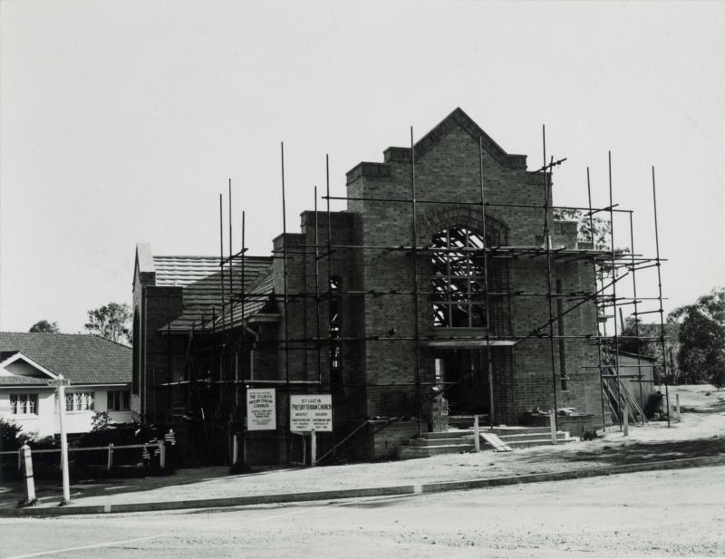 This is an image of ‘Construction of the St. Lucia Presbyterian Church, Queensland’, c.1955-1975, viewed from the corner of Swann Road and Hawken Drive, St Lucia, looking south.
