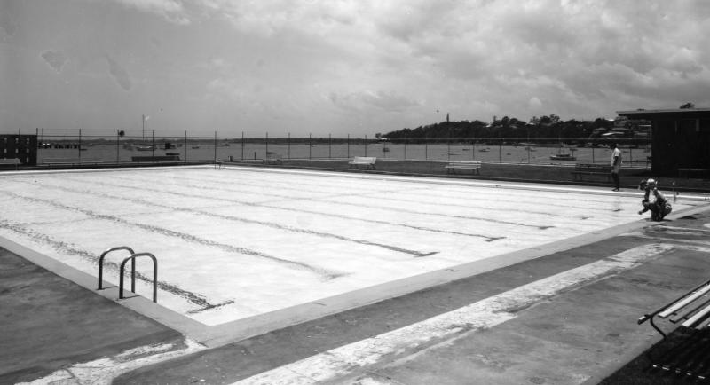 This is an image of 'Manly Swimming Pool and Amenities Block - Manly - 1964', 2 December 1964, showing a view over the swimming pool toward Manly Boat Harbour, looking south-east.