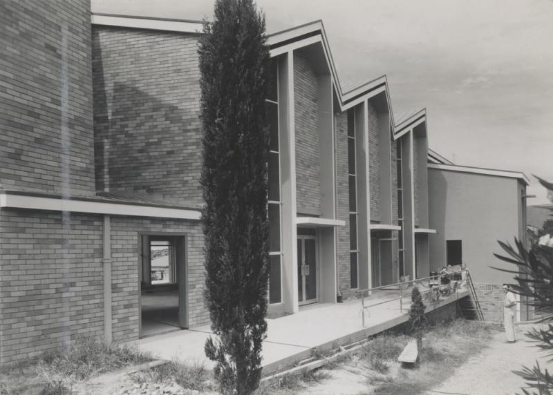 This is an image of ‘St. Francis of Assisi Anglican Church, Nundah, Queensland, 1959', showing the side (north-west) elevation of the church during construction, looking south.