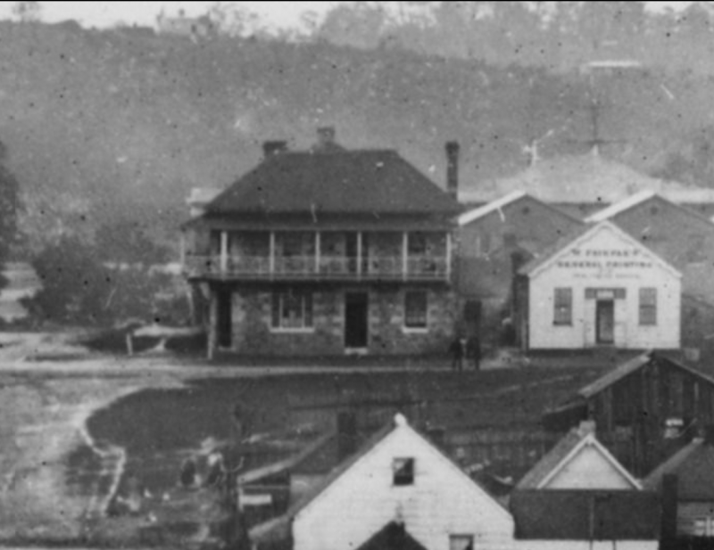 This is a detail view of the 'Victory Hotel', then known as the 'Prince of Wales Hotel', from the image 'Charlotte Street, Brisbane, during the 1864 flood', viewed from Charlotte & George streets, Brisbane, looking north.